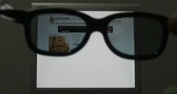 На изображении показаны чёрные 3D-очки, которые держат перед экраном монитора. Через линзы очков частично виден веб-сайт с названием «Instructables» — это платформа с инструкциями и проектами «сделай сам»