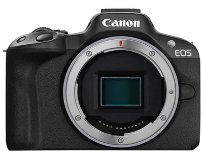 Фронтальный вид беззеркальной камеры Canon EOS R50 с открытым байонетом для установки объектива. Корпус чёрного цвета, с текстурированной рукояткой. Логотип «Canon» и надпись «EOS» хорошо видны на верхней части корпуса