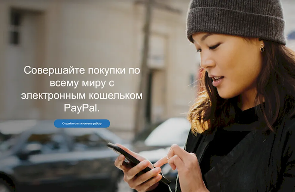 Девушка использует сервис PayPal на смартфоне для оплаты услуг
