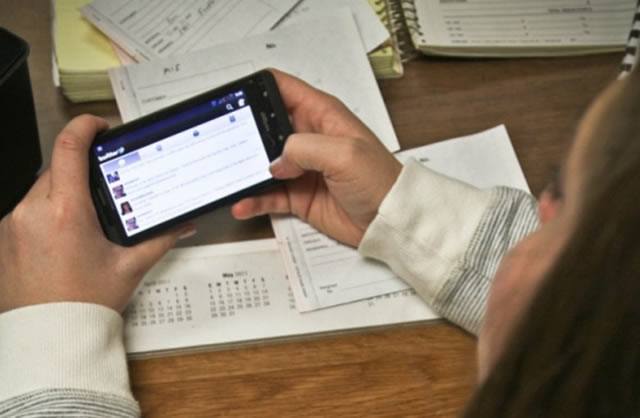 Девушка использует современный смартфон для посещения социальной сети